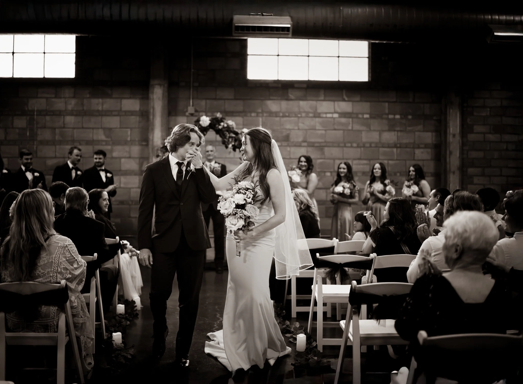 A candid black-and-white wedding ceremony moment